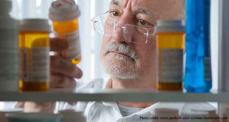 Picture of an elderly man inspecting his medications